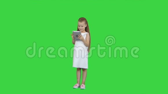 绿色屏幕上有平板电脑的小女孩色度键视频的预览图