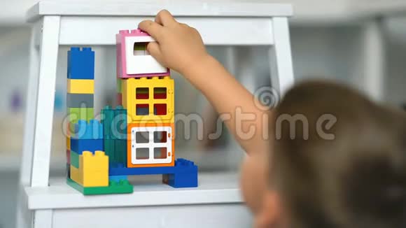 小孩在儿童房的地板上玩逻辑玩具视频的预览图