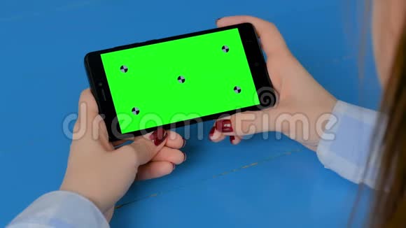 女人看黑色智能手机与空绿色屏幕色度关键概念视频的预览图