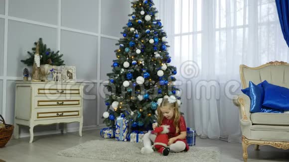 圣诞前夜穿着睡衣和兔子在壁炉旁玩耍的快乐小女孩视频的预览图