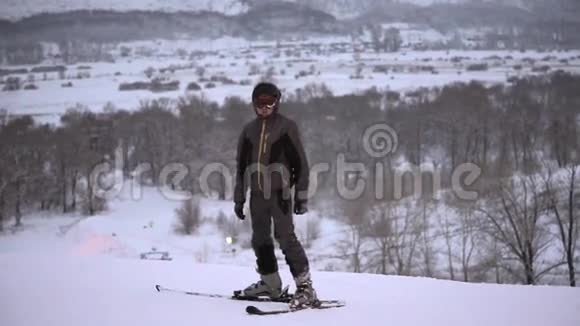 运动男子站在滑雪服和运动滑雪在高山上视频的预览图