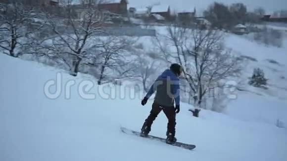 活跃的年轻人在滑雪板上高速滑下斜坡视频的预览图