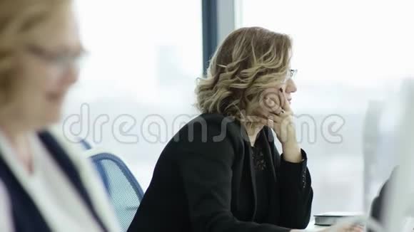 有魅力的年轻女商人在办公室通过电脑工作特写时髦的学生女孩浏览视频的预览图