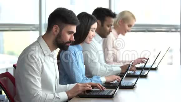 人们坐在办公室用笔记本电脑工作视频的预览图