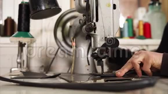 机械缝纫机的特写镜头一个人缝制一件皮件的部分视频的预览图