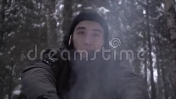 年轻人坐在篝火前的树林里耳边是铅笔视频的预览图