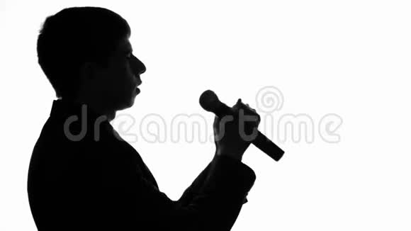 一个男人用麦克风有感情地唱歌的音乐会的剪影视频的预览图
