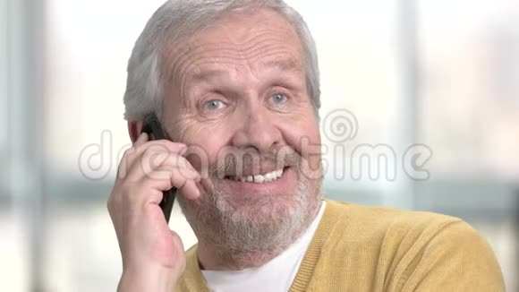 友好的高加索退休者在电话里交谈视频的预览图