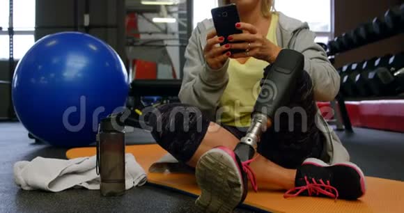 4k健身室使用手机的老年妇女视频的预览图