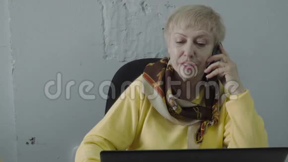退休妇女在办公室打电话视频的预览图