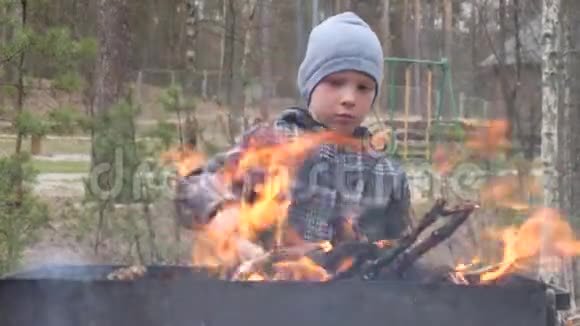 男孩在烤架里生火做饭乡村休息视频的预览图