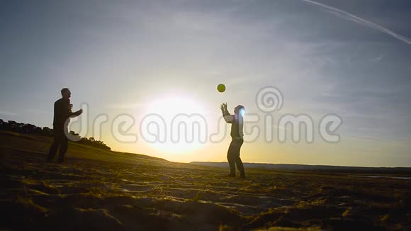 训练男子在阳光下在沙滩上打排球在春天的傍晚在沙滩上打排球视频的预览图
