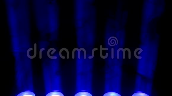 蓝色聚光灯和黑色背景上的烟雾抽象的深色背景与明亮的蓝色舞台聚光灯灯光和灯光视频的预览图