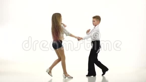 穿着漂亮服装的小舞者表演一支舞蹈白色背景缓慢的一元视频的预览图