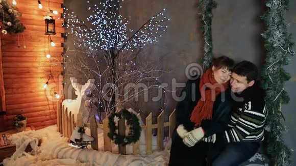 一对相爱的夫妇在童话装饰的背景下互相欣赏圣诞节和新年主题视频的预览图