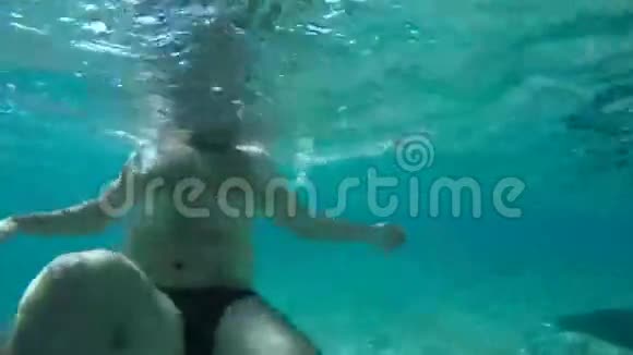 水下胖子在蓝色的海洋里游泳视频的预览图