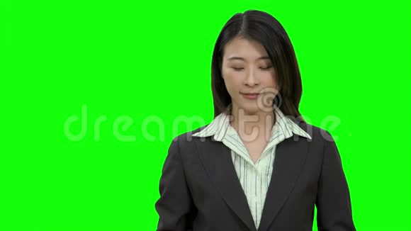 亚洲女商人在绿屏上竖起大拇指视频的预览图