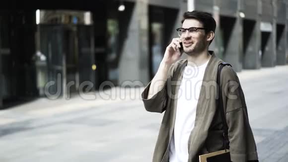 戴眼镜的大胡子嬉皮士在外面打电话笑视频的预览图