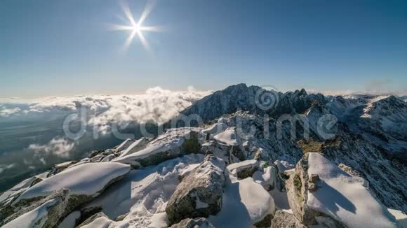 冬天的日落云层之上的雪山岩石和雪的时间流逝视频的预览图