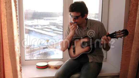演奏乐器坐在窗台上的人在吹口琴视频的预览图