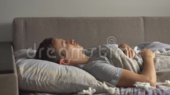 一个生病的年轻人正在床上咳嗽视频的预览图