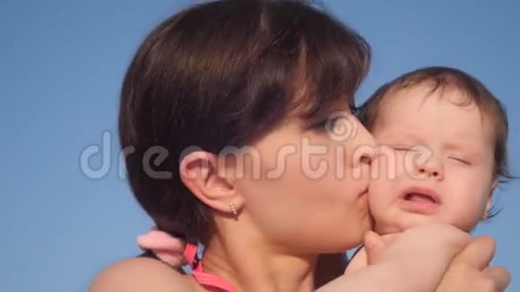 妈妈吻婴儿对着蓝天视频的预览图