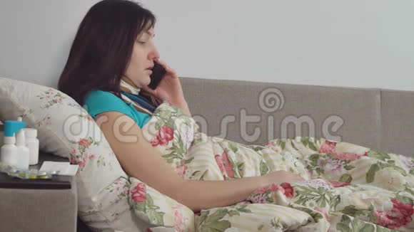 生病的女人躺在床上在家里打电话视频的预览图