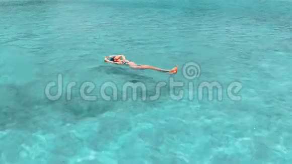 美丽的年轻女子漂浮在晶莹剔透的水中空中旋转拍摄视频的预览图