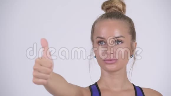 年轻的金发美女竖起大拇指的脸视频的预览图