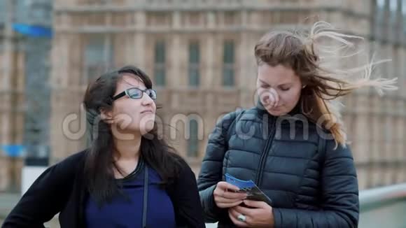 在刮风的一天在伦敦散步两个女孩在观光旅行慢动作视频的预览图