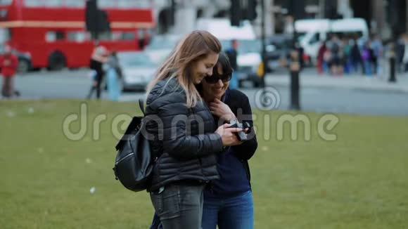 两位年轻女性在镜头前查看照片伦敦慢动作观光视频的预览图