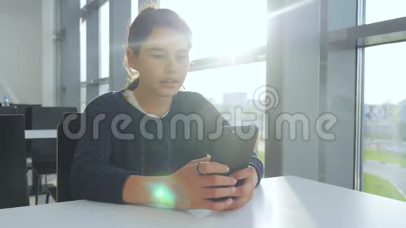 少女在生活方式桌上的一家咖啡馆里用智能手机聊天交流视频的预览图
