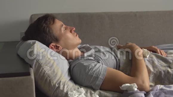 一个生病的年轻人正在床上咳嗽视频的预览图