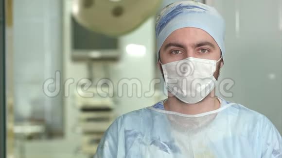 有经验的年轻外科医生戴着面罩的严肃男人看着摄像机视频的预览图