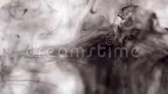 白色背景下水中黑色墨水的特写一滴黑色墨水在水中飞溅创造了抽象视频的预览图