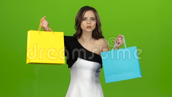 女孩留着购物袋怀疑该选择什么绿色屏幕视频的预览图