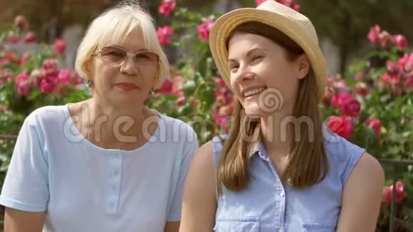 快乐的家庭享受假期母亲和女儿坐在长凳上在街上放松视频的预览图
