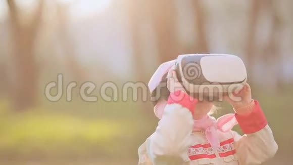 小女孩戴着虚拟现实护目镜看电影或玩电子游戏快乐微笑的孩子在虚拟现实中寻找视频的预览图