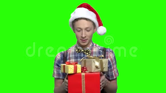 带礼物盒和圣诞帽的少年视频的预览图