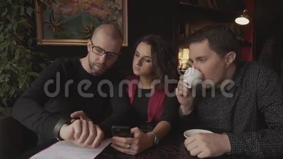 咖啡店里的生意伙伴谈论他们的项目视频的预览图