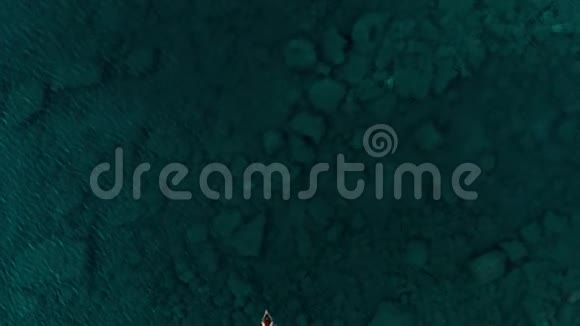 空中慢动作女人漂浮在蓝色水面上在透明的地中海游泳俯视夏季度假视频的预览图