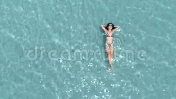 美丽的年轻女子漂浮在晶莹剔透的水中空中旋转拍摄视频的预览图