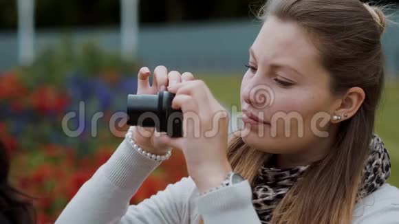 年轻女孩正在公园拍照视频的预览图