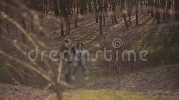 日落时分一对相爱的情侣在森林里散步视频的预览图