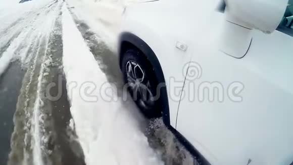 汽车车轮在冬天的雪道上打滑视频的预览图