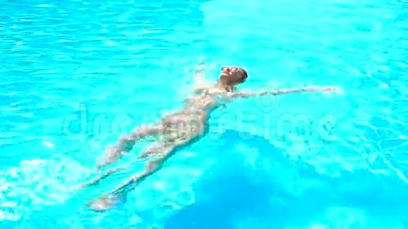 一个戴眼镜的漂亮女孩在游泳池里背上漂浮视频的预览图