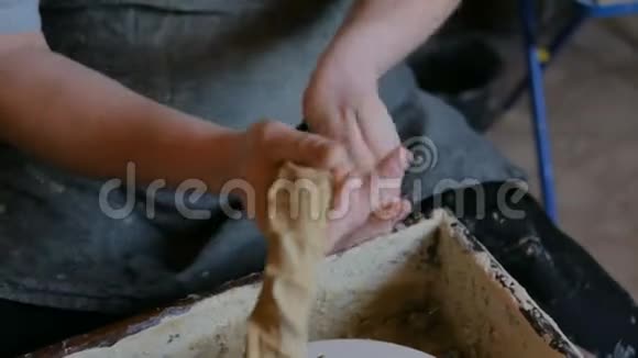 职业男陶工在陶器作坊里揉泥巴视频的预览图