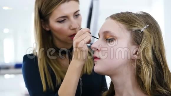 将化妆应用于面部模型的过程粉眼影涂妆用刷子主诊工作视频的预览图