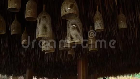 稻草装饰吊灯悬挂在棕榈叶屋顶下视频的预览图