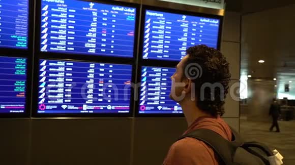 旅客看机场候机楼的时刻表国际航班商务旅客视频的预览图